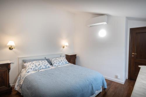 a bedroom with a bed with a blue comforter at appartamento gli archiccioli in Assisi