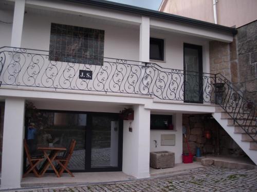 a balcony on a house with a table and a table at Casa do avô Serafim in Cetos