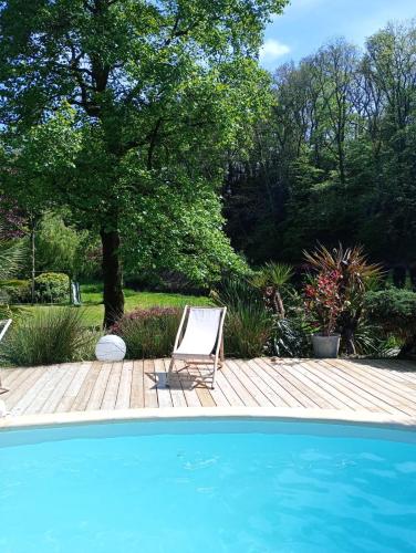 une terrasse avec une chaise et une piscine dans l'établissement Gîte de la Rivière, à Pluvigner