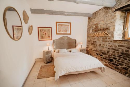 une chambre avec un lit et un mur de briques dans l'établissement Gîte de la Rivière, à Pluvigner