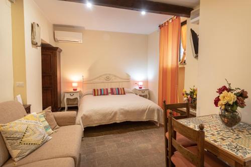 a bedroom with a bed and a couch in a room at appartamento gli archiccioli in Assisi