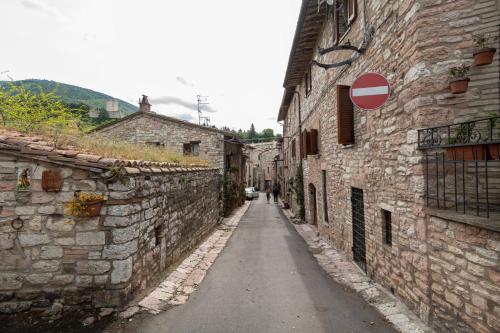 an alley with stone buildings and a red stop sign at appartamento gli archiccioli in Assisi