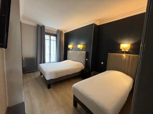 a hotel room with two beds and a window at Hotel Le Jacquemart in Dijon