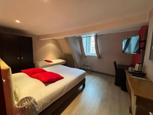 a hotel room with two beds and a flat screen tv at Hotel Le Jacquemart in Dijon