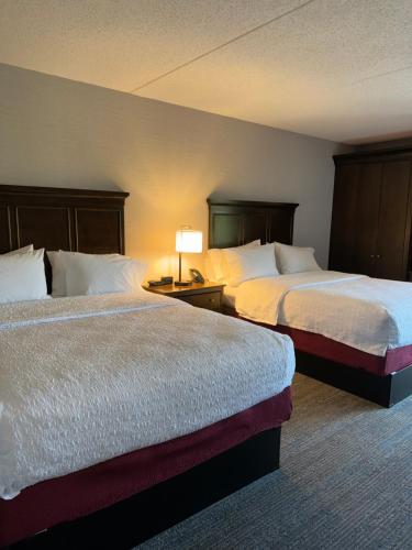 a hotel room with two beds and a lamp at Hampton Inn New Bedford/Fairhaven in Fairhaven