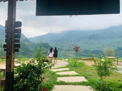 two people standing on a path looking at the mountains at Du peak home in Làng Cac