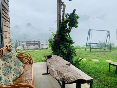 a wooden table with a bench and a swing at Du peak home in Làng Cac