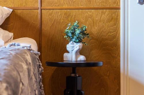 a vase with flowers on a table next to a bed at Villa Ernesaks - Private yard and grill in Tallinn