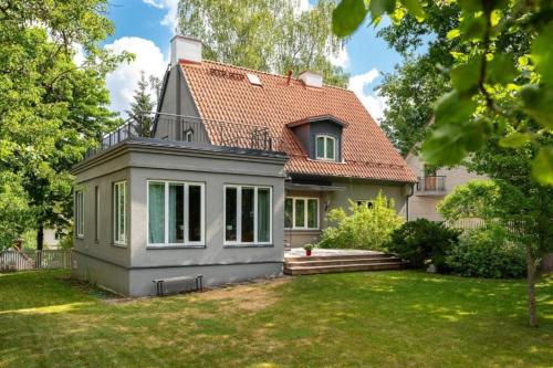 a small house with a red roof at Villa Ernesaks - Private yard and grill in Tallinn