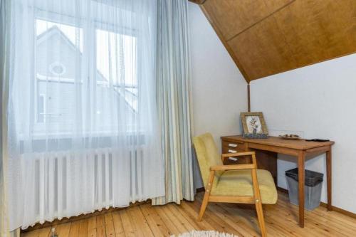 a desk with a chair next to a large window at Villa Ernesaks - Private yard and grill in Tallinn