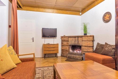 a living room with a fireplace and a tv at Villa Ernesaks - Private yard and grill in Tallinn