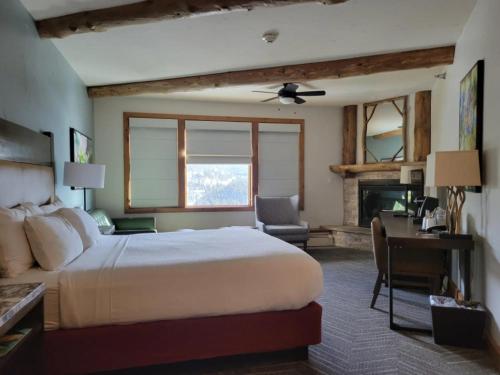 a bedroom with a bed and a desk and a fireplace at The Lodge at Breckenridge in Breckenridge