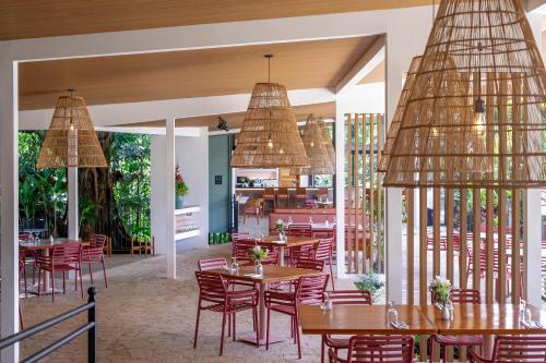 a restaurant with tables and chairs and chandeliers at Hotel Arenal Kioro Suites & Spa in Fortuna