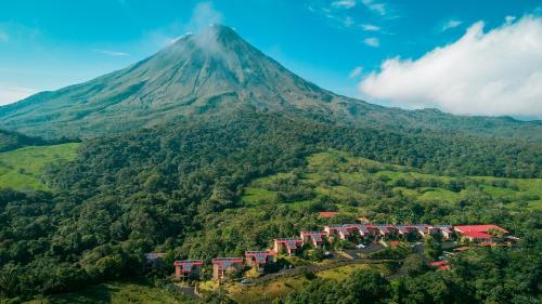 a mountain in the distance with houses and trees at Hotel Arenal Kioro Suites & Spa in Fortuna