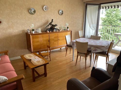 un salon avec une table et une salle à manger dans l'établissement Proche de Paris résidence Le Moulin de Chennevieres, à Chennevières-sur-Marne