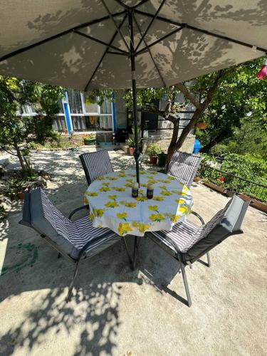 a table and two chairs under an umbrella at Guest house Me and grandfather-მე და პაპა in Dedoplis Tskaro