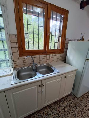 eine Küche mit Spüle und Fenster in der Unterkunft Με Θεα!! in Stomio