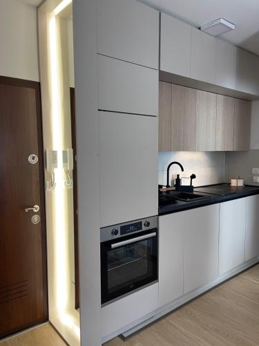 a kitchen with white cabinets and a sink and a stove at Apartman Mandić Žabljak in Žabljak