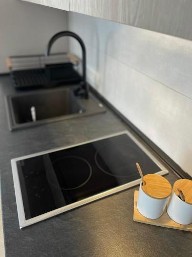 a kitchen counter with two mugs and a sink at Apartman Mandić Žabljak in Žabljak