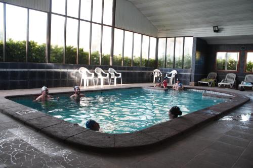 a swimming pool with a large group of people in it at Hotel Borde Lago in Puerto Varas