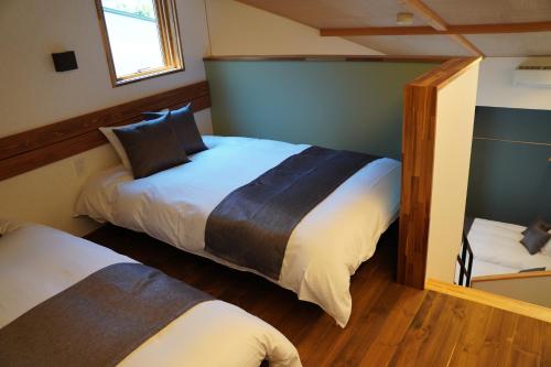 a bedroom with two beds and a mirror at SAUNA VILLA 然 in Nagano