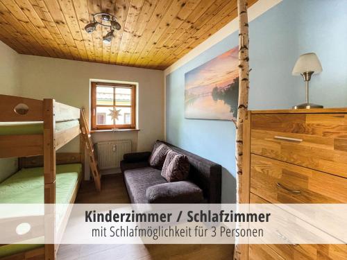 una stanza con un divano e un letto a castello di Ferienwohnung Hauzenberg mit Pool & Sauna a Hauzenberg