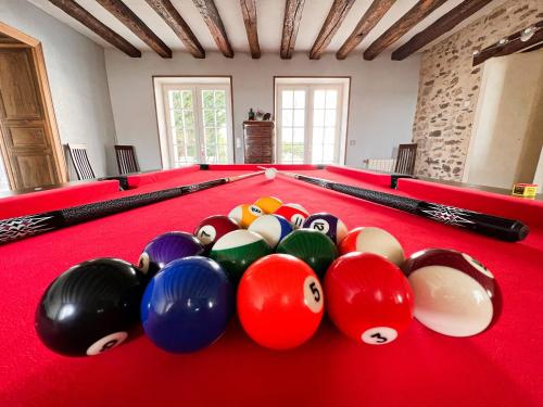a red pool table with billiard balls on it at Le domaine de Brie in Châtillon-la-Borde