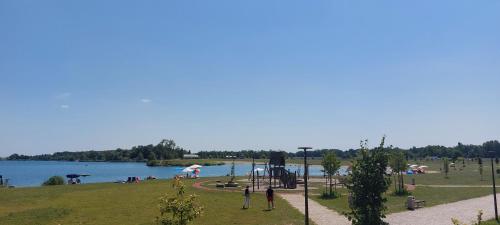 a park with people sitting on the grass near a lake at Apartma Vita in Moravske Toplice