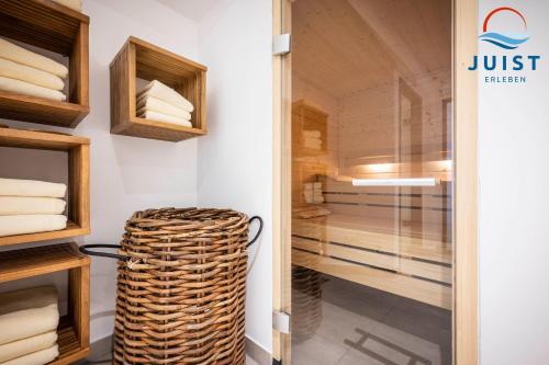 a walk in closet with a wicker stool in a room at Haus Inselresidenz Strandburg Wohnung S302 in Juist