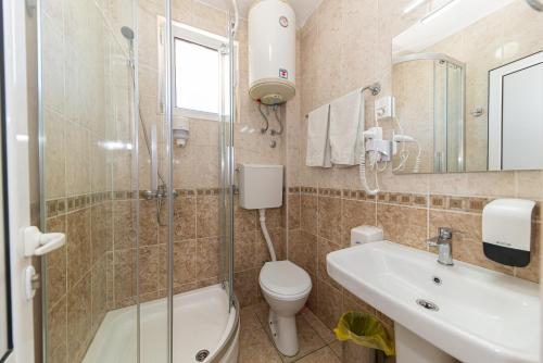 a bathroom with a toilet and a sink and a shower at Villa Dana in Bar