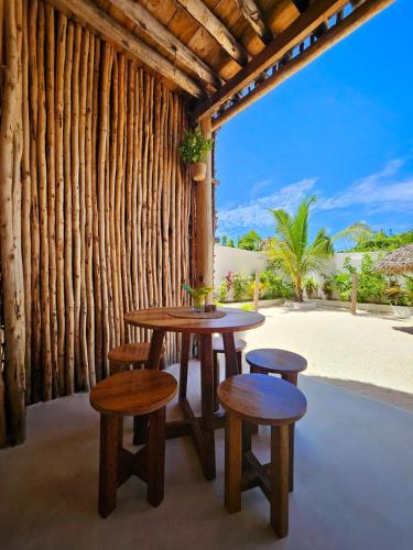 a table and stools in a room with a view at Mfumbwi Twins Villa in Jambiani