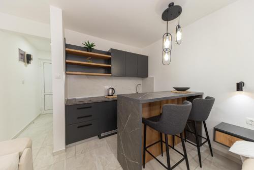 a kitchen with a counter and stools in a room at Villa Dana in Bar