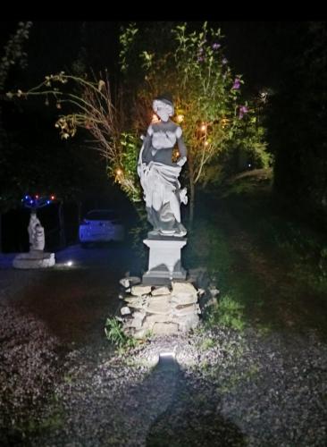 a statue in a yard at night with lights at Finca la Vegacha casa tradicional pasiega in San Roque de Ríomiera