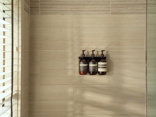 three bottles on a wall in a bathroom at Montauk Yacht Club in Montauk