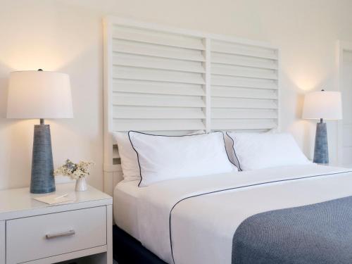 a bedroom with a white bed with two lamps on it at Montauk Yacht Club in Montauk