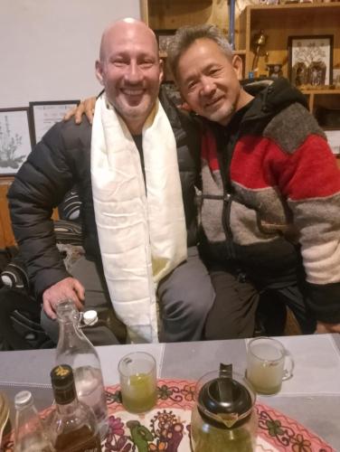 two men posing for a picture at a table at Rock Castle Residency in Leh