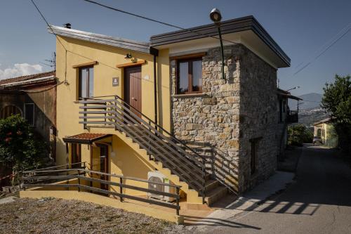 ein gelbes Haus mit einer Seitentreppe in der Unterkunft Agriturismo e B&B Selvanera in Postiglione