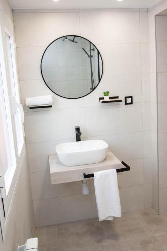 a bathroom with a sink and a mirror at Pregonero Urban Suites - Verde in Soria