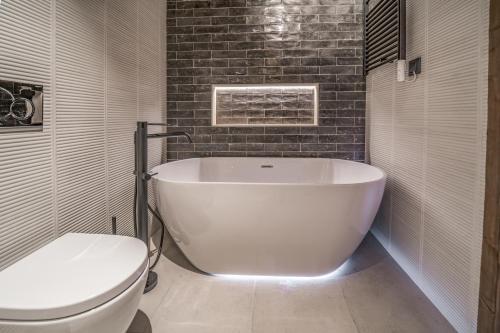a white bath tub in a bathroom with a toilet at Pleta del Tarter Lodge in El Tarter
