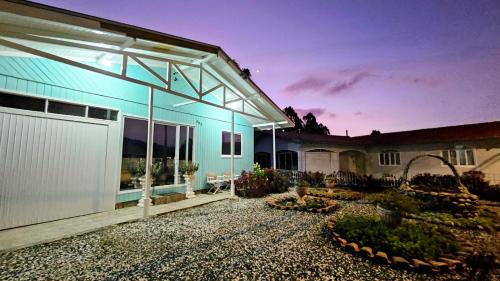 a house with a glass facade with a patio at Casa de Temporada Doce Luar in Urubici
