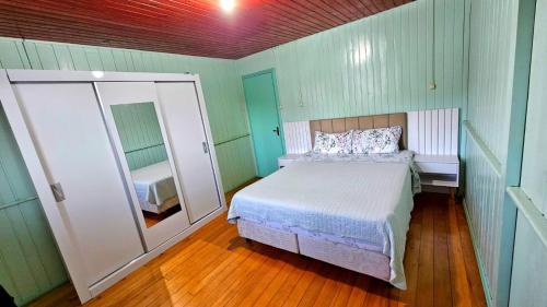 a bedroom with a bed and a large mirror at Casa de Temporada Doce Luar in Urubici