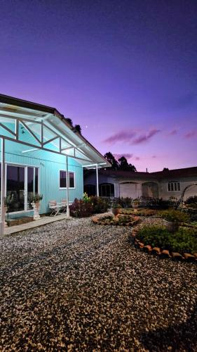 a blue house with a gravel driveway in front of it at Casa de Temporada Doce Luar in Urubici