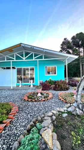 a blue house with a garden in front of it at Casa de Temporada Doce Luar in Urubici