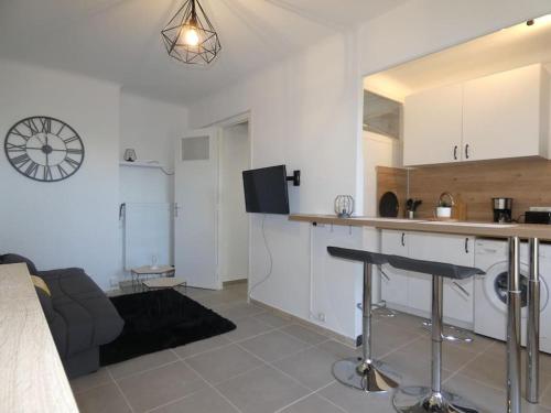 Il comprend une cuisine et un salon avec un comptoir. dans l'établissement Studio moderne en rez de jardin, à Antibes