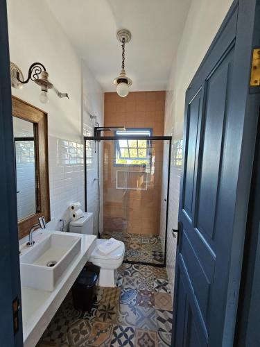 a bathroom with a toilet and a sink and a tub at Casa da Tuta Pousada in Tiradentes