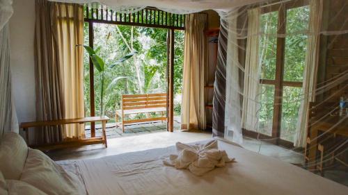 a bedroom with a bed and a large window at Eco Breeze - Unawatuna in Galle