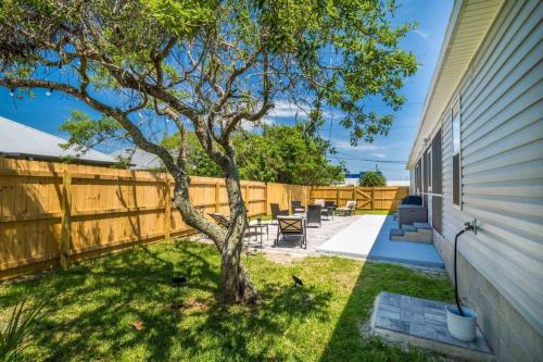 a backyard with a tree and a fence at Charming and delightful getaway! Walk to Beach in Saint Augustine