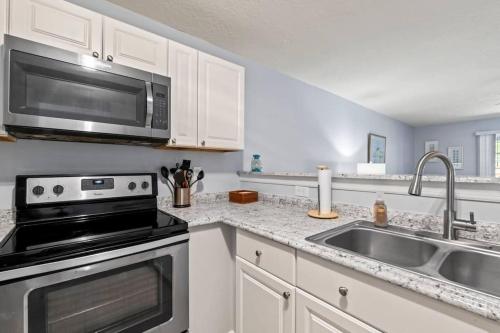 a kitchen with a sink and a microwave at Charming and delightful getaway! Walk to Beach in Saint Augustine
