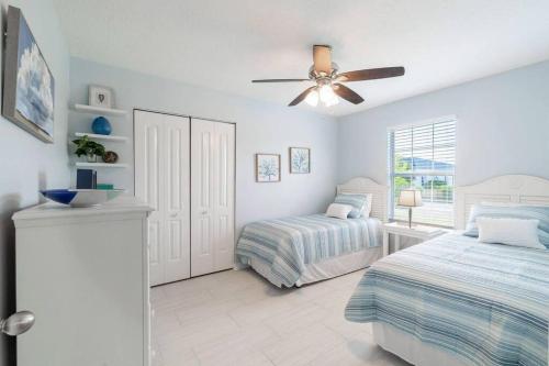 a bedroom with two beds and a ceiling fan at Charming and delightful getaway! Walk to Beach in Saint Augustine