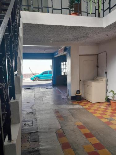 グアテマラシティにあるHotel el Mesón, Guatemalaの駐車場に青い車が停まっている、空っぽの廊下
